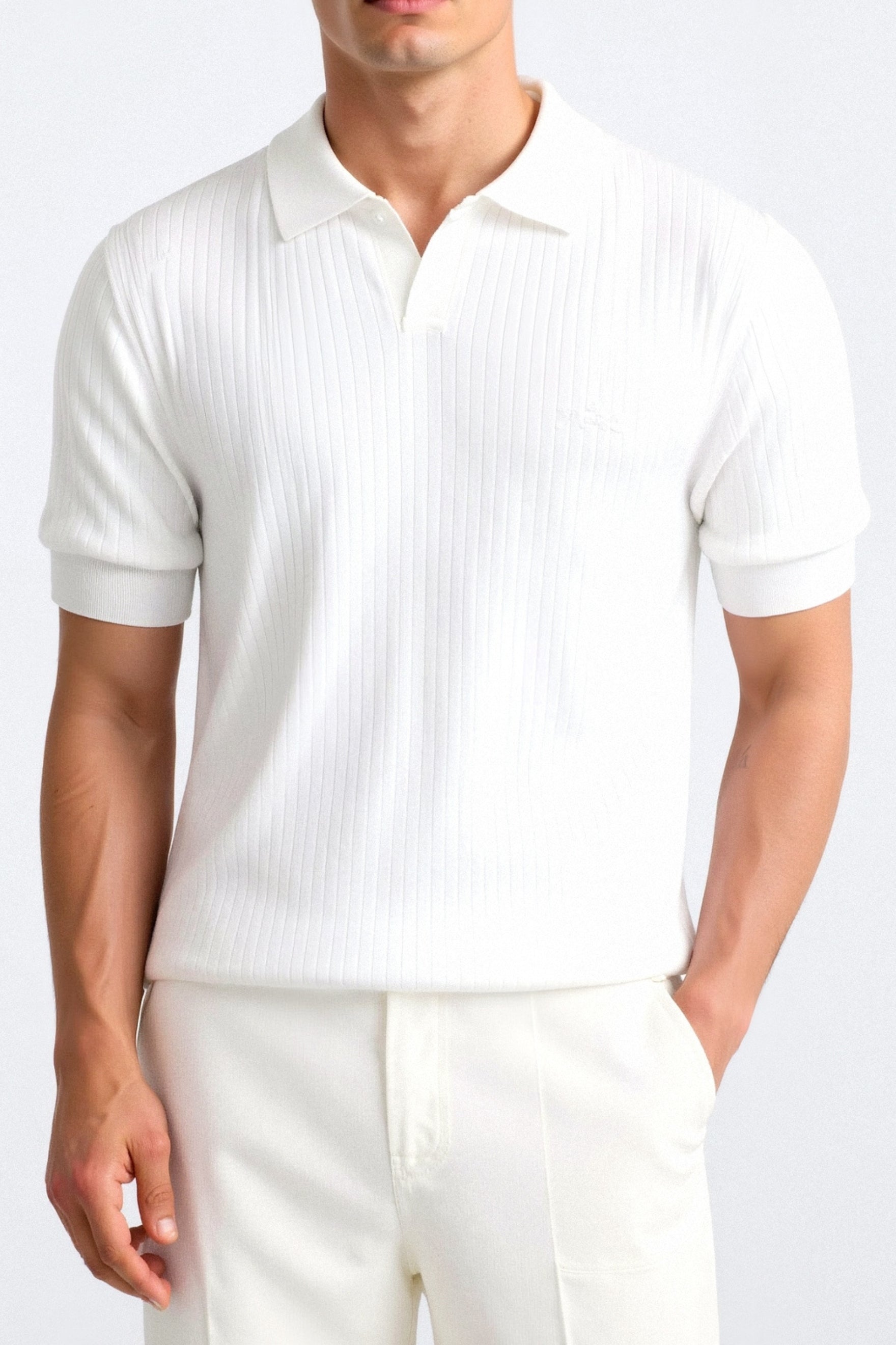 Man wearing a white ribbed polo shirt and pants on a white background