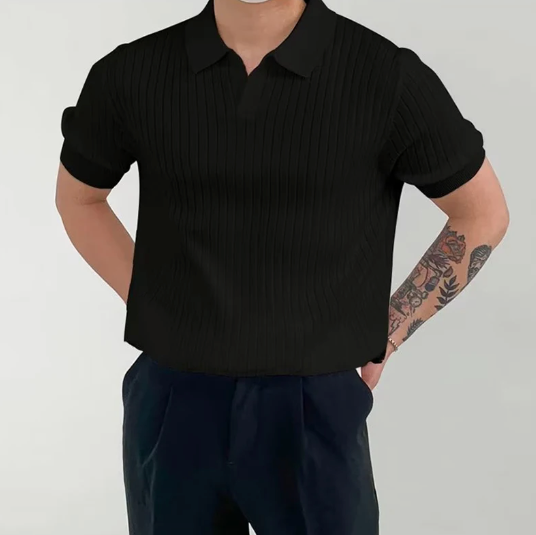 Person wearing a black ribbed shirt and dark pants on a plain background